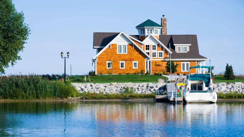 Waterfront shingled home with a boat at the dock
