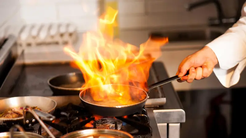 Chef flambéing in a restaurant kitchen